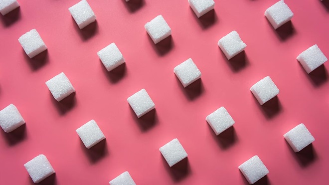 sugar cubes on pink background added sugar